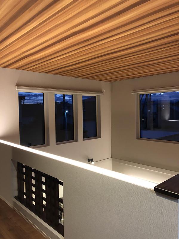 IMG_6453　吹抜け天井を照らす照明を手摺壁に仕込み、木目の質感を強調している.JPG